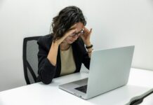 두통 유발하는 승모근 과긴장, 해결법은? a woman sitting in front of a laptop computer