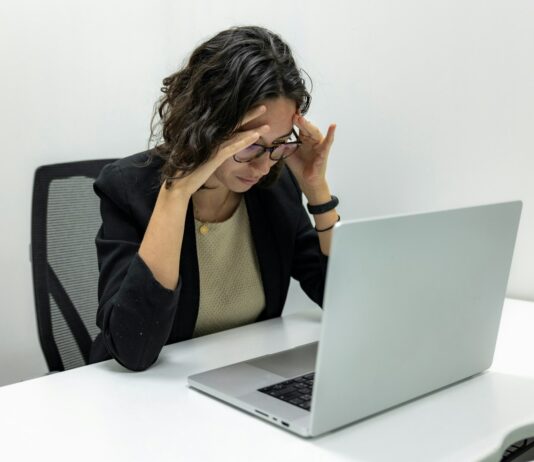 두통 유발하는 승모근 과긴장, 해결법은? a woman sitting in front of a laptop computer