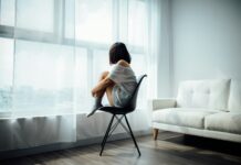 우울감 완화를 돕는 현실적인 생활습관 woman sitting on black chair in front of glass-panel window with white curtains