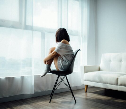 우울감 완화를 돕는 현실적인 생활습관 woman sitting on black chair in front of glass-panel window with white curtains