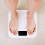 요요 없는 다이어트를 위한 운동 습관 만들기 person standing on white digital bathroom scale