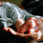 난임 케어, 건강한 임신 준비의 시작… 필라테스가 주목받는 이유 person holding baby feet