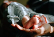 난임 케어, 건강한 임신 준비의 시작… 필라테스가 주목받는 이유 person holding baby feet