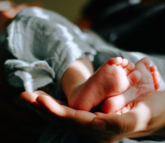 난임 케어, 건강한 임신 준비의 시작… 필라테스가 주목받는 이유 person holding baby feet