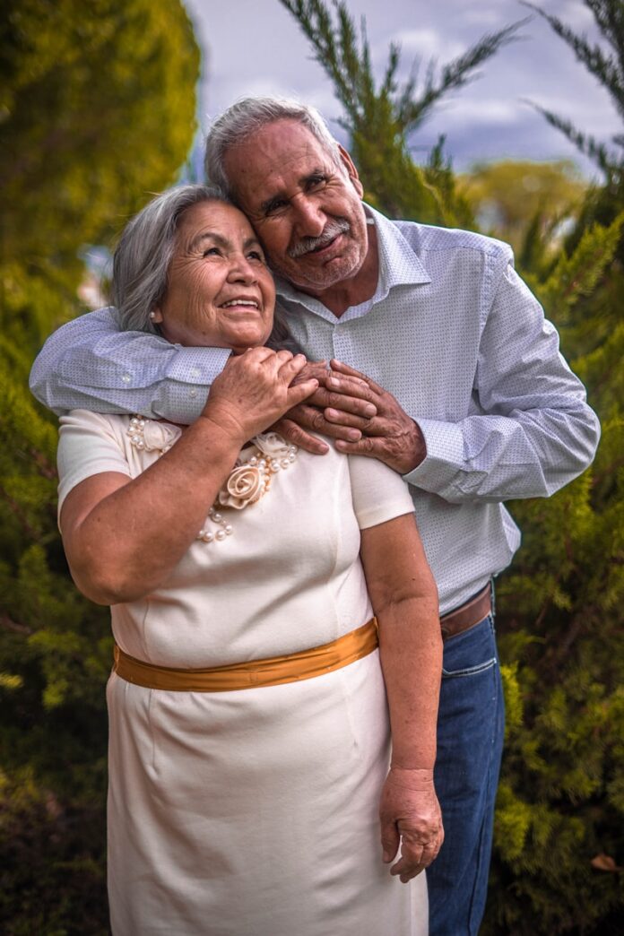 Photo by Hector Reyes man in white dress shirt hugging woman in white dress
