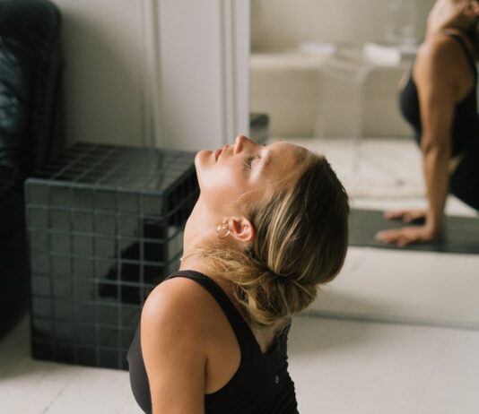 스트레칭으로 관리하는 부종, 일상 속 작은 움직임이 중요하다 A woman in black athletic wear performing an upward dog yoga pose on a mat